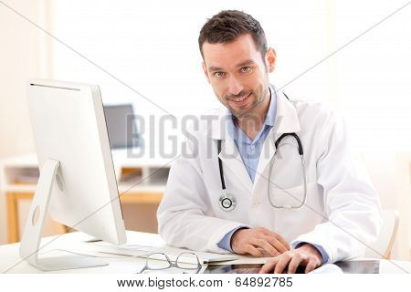 Portrait Of A Young Smiling Doctor In His Office