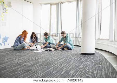 Creative businesspeople working on floor in office