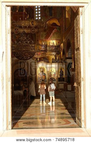 PODGORICA, MONTENEGRO - AUGUST, 17: a couple inside the Cathedral of the Resurrection in Podgorica looking at Jesus Christ icons. Shot in 2014