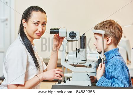 Optometry concept. Female optometrist optician doctor examines eyesight of child boy in eye ophthalmological clinic 