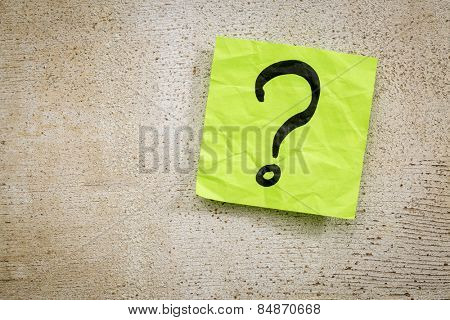 uncertainty or doubt concept - a question mark on a sticky note against rustic brand wood