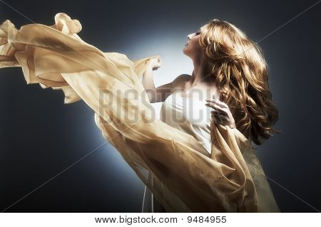 Portrait de la jeune femme contre un tissu volant