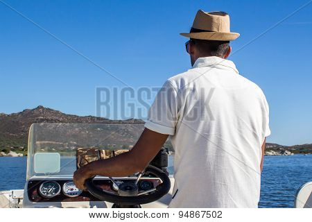 Man Driving A Boat Near The Coast