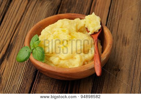 Polenta With Green Basil In Wooden Bowl With Wooden Spoon