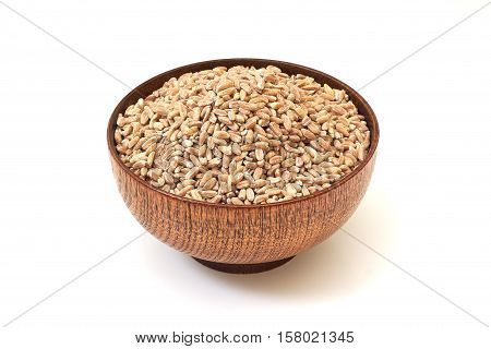 Spelt grain (dinkel wheat) in wooden bowl isolated on white background