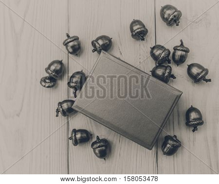 Christmas composition.Present box with acorns.White wooden table.Mokup with space.Black and white.Toned