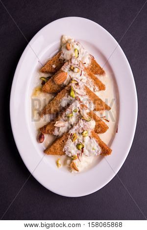 Shahi Tukda prepared - deep fried bread in ghee, garnish with sweetened cream and dry fruits.