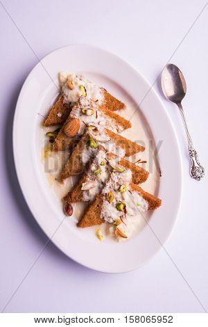Shahi Tukda prepared - deep fried bread in ghee, garnish with sweetened cream and dry fruits.