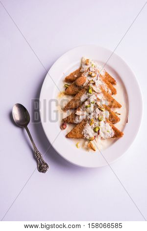 Shahi Tukda prepared - deep fried bread in ghee, garnish with sweetened cream and dry fruits.