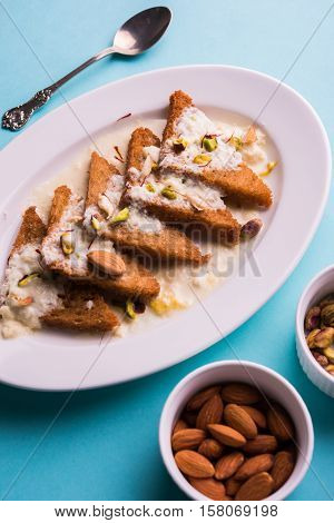 Shahi Tukda prepared - deep fried bread in ghee, garnish with sweetened cream and dry fruits.