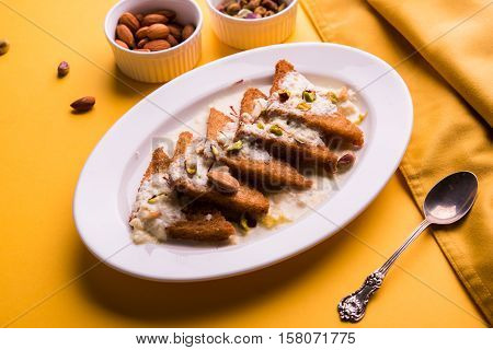 Shahi Tukda prepared - deep fried bread in ghee, garnish with sweetened cream and dry fruits.