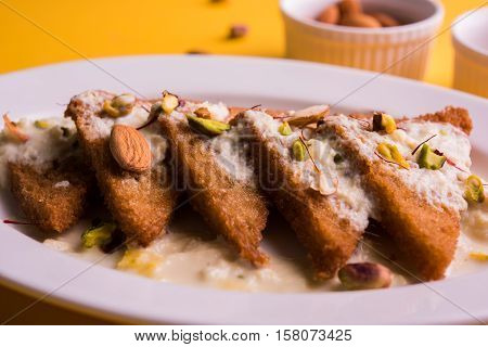 Shahi Tukda prepared - deep fried bread in ghee, garnish with sweetened cream and dry fruits.