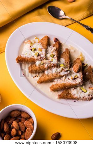 Shahi Tukda prepared - deep fried bread in ghee, garnish with sweetened cream and dry fruits.