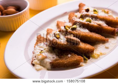 Shahi Tukda prepared - deep fried bread in ghee, garnish with sweetened cream and dry fruits.