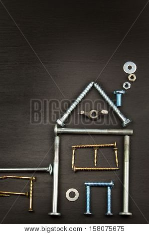 Building a house for the family. Plans to build a small house. Architect designing a house for a young family. House from nails and screws. Needed for building. Ideas about building a house.