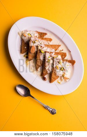 Shahi tukda prepared - deep fried bread in ghee, garnish with sweetened cream and dry fruits.