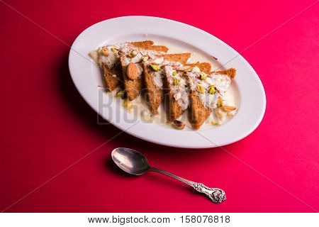 Shahi tukda prepared - deep fried bread in ghee, garnish with sweetened cream and dry fruits.