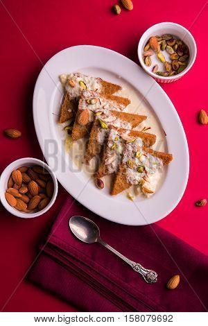 Shahi tukda prepared - deep fried bread in ghee, garnish with sweetened cream and dry fruits.