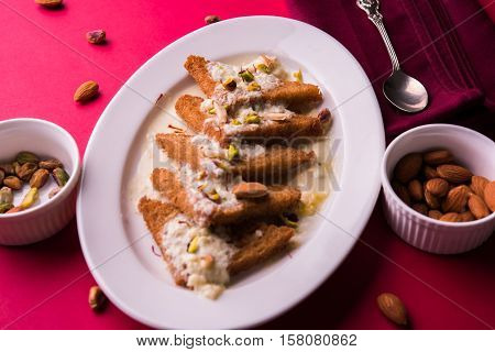 Shahi tukda prepared - deep fried bread in ghee, garnish with sweetened cream and dry fruits.