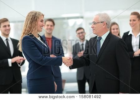 Great job! Two cheerful business people shaking hands while thei