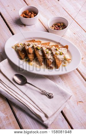 Shahi tukda prepared - deep fried bread in ghee, garnish with sweetened cream and dry fruits.