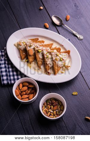 Shahi tukda prepared - deep fried bread in ghee, garnish with sweetened cream and dry fruits.