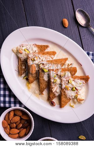 Shahi tukda prepared - deep fried bread in ghee, garnish with sweetened cream and dry fruits.
