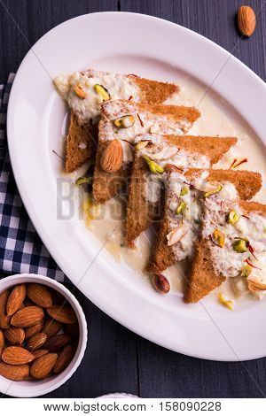 Shahi tukda prepared - deep fried bread in ghee, garnish with sweetened cream and dry fruits.