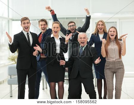 Victory in business. Happy businessman and business team on offi