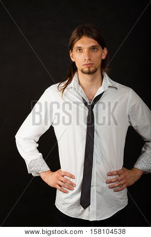 Masculinity fashion concept. Man in shirt and tie. Young long haired male on dark background.