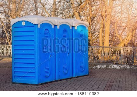 A row of bio toilets in public place hit by the sun