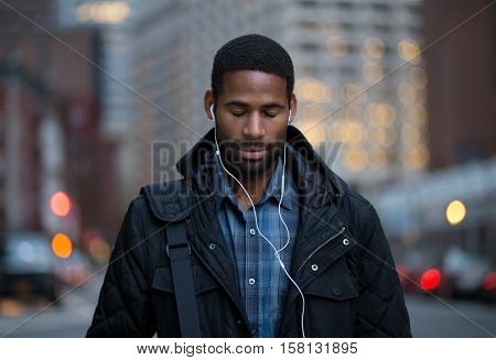 Portrait of African American man listening to music and taking in before work. Photographed in NYC 2016.