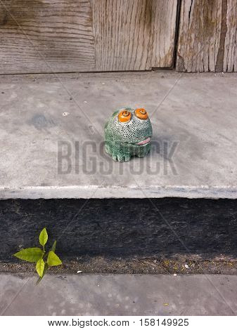 Toy frog or toad sitting on the contry porch