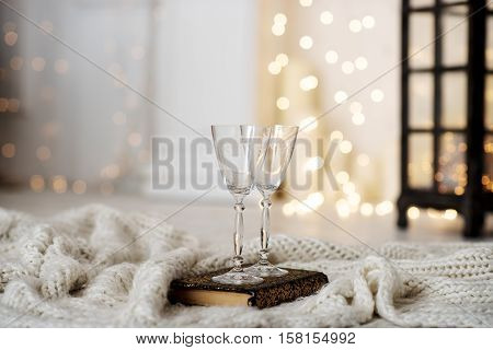 Beautiful two glasses of champagne standing on the table in the background of a blurred room with a decorated Christmas tree and fireplace. Soft focus.