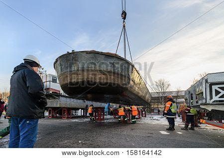 MOSCOW, RUSSIA - NOVEMBER 11, 2016: State Unitary Enterprise Mosvodostok performs recovery vessels on coastal winter parking. Dockers set barge on metal supports.