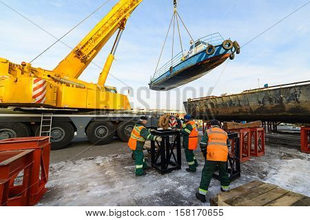 MOSCOW, RUSSIA - NOVEMBER 11, 2016: State Unitary Enterprise Mosvodostok performs recovery vessels on coastal winter parking. Workers prepare a place in the ship installation.