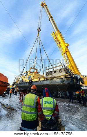 MOSCOW, RUSSIA - NOVEMBER 11, 2016: State Unitary Enterprise Mosvodostok performs recovery vessels on coastal winter parking. Workers control the installation of the ship.
