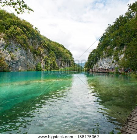 Gavanovac lake among green trees and high white rocks in summer. Plitvice lakes national park Croatia
