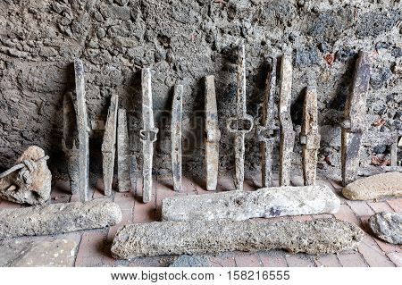 Ancient iron pickaxe heads used to break up stone masonry and hard ground.