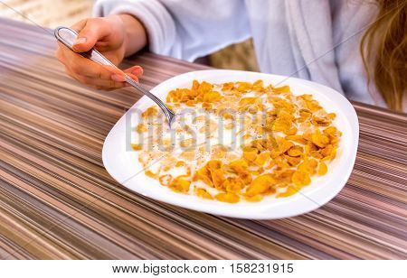 Cornflakes in milk in the white plate