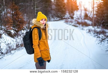 woman traveler with a backpack in the winter forest