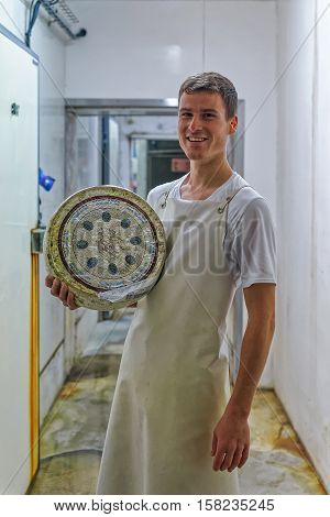 Cheese Maker Holding Wheel Of Cheese On Franche Comte Dairy