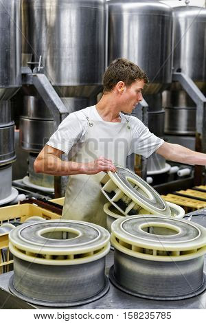 Cheesemaker Putting Young Gruyere Comte Cheese At Forms In Dairy