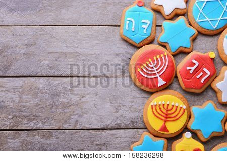 Tasty glazed cookies for Hanukkah on wooden table