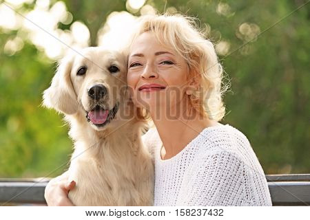 Senior woman sitting on bench with dog, closeup