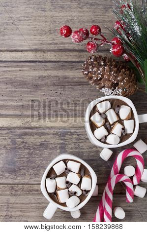 Christmas still life - two cups of hot chocolate with marshmallow candies and branch of fir with berries. Copy space