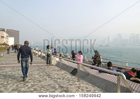 People Walking At Embankment Of Victoria Harbor In Hong Kong