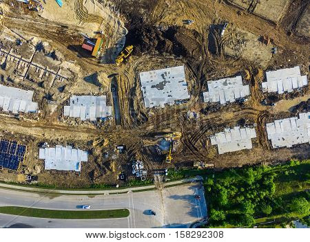 Looking straight down above construction with foundation squares and pipelines and construction vehicles Austin Texas USA aerial view wide angle