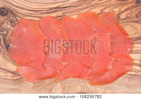 Smoked wild pacific sockeye salmon on olive wood cutting board
