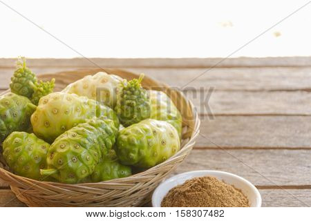 Noni fruit  and  noni powder on wooden table.Fruit for health and herb for health.002